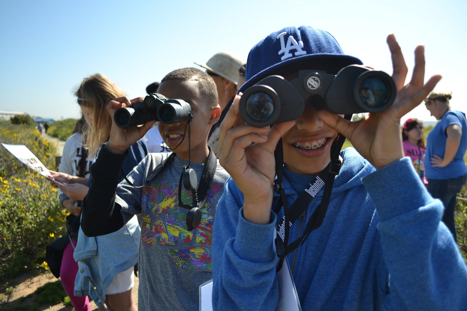 two children looking through binoculars